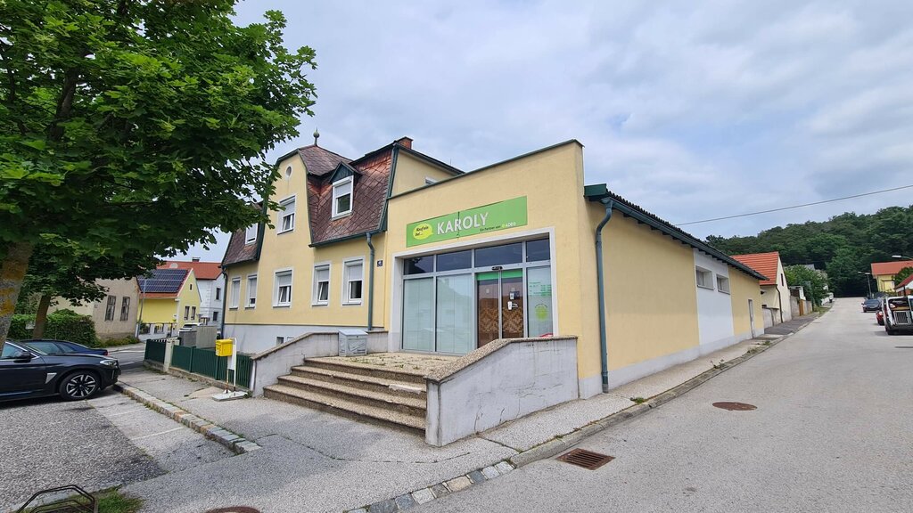 Gelbes Supermarktgebäude angrenzend an ein Wohnhaus
